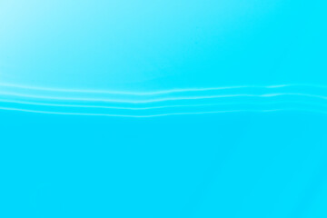 Defocus blurred transparent blue colored clear calm water surface texture with splashes reflection. Trendy abstract nature background. Water waves in sunlight with copy space. Blue watercolor shine.