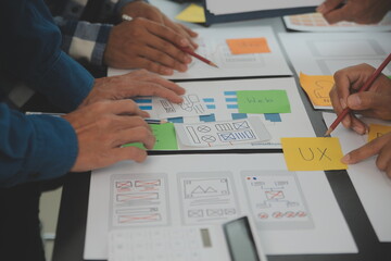 Close up ux developer and ui designer brainstorming about mobile app interface wireframe design on...