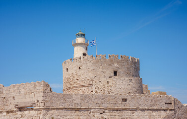 Mandraki port and fort of St. Nicholas. Rhodes, Greece. Hirschkuh statue in the place of the...