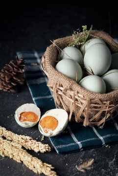 salted eggs, duck eggs in the bamboo basket and sackcloth with dark background. split salted eggs.