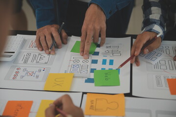 Close up ux developer and ui designer brainstorming about mobile app interface wireframe design on...