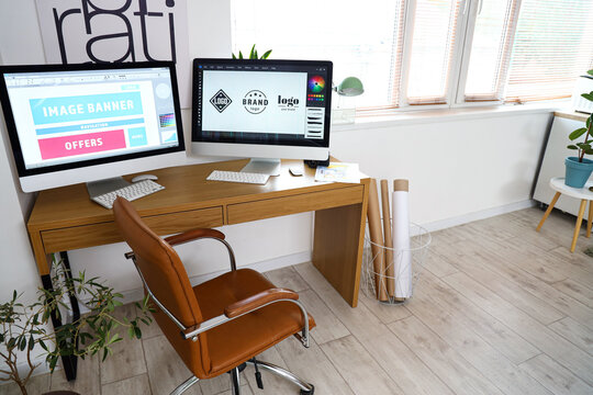 Graphic designer's workplace with computer monitors in office