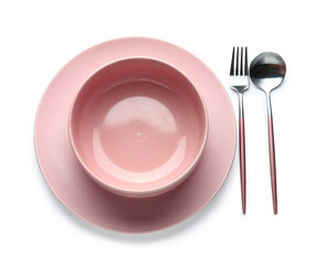 Pink bowl, plate and cutlery isolated on white background