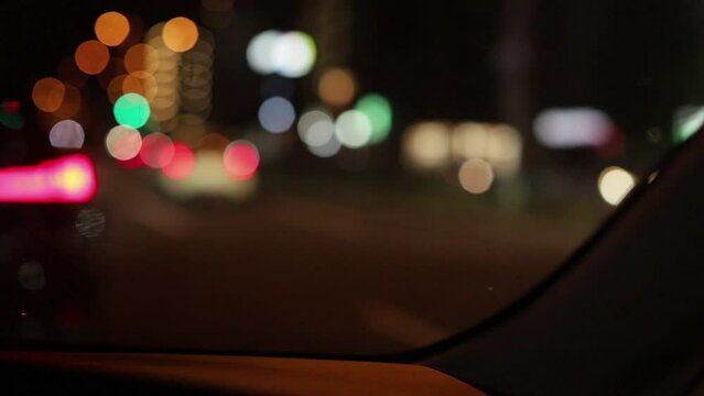 駐車中の車の車窓から見た夜の都市の夜景の風景