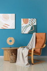 Obraz premium Interior of living room with plaid on armchair and table