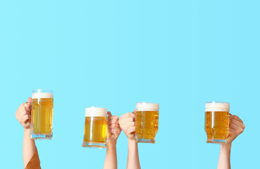 Woman and man with mugs of cold beer on blue background