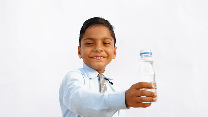 Indian school kids drinking water. Side view studio portrait of a cute child drinks water from white reusable bottle.