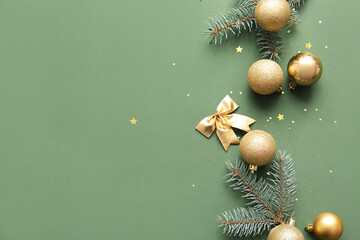 Christmas tree branches with balls and bow on green background