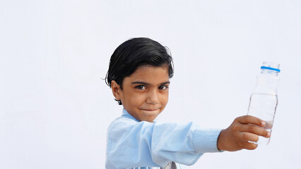 Indian school kids drinking water. Side view studio portrait of a cute child drinks water from white reusable bottle.