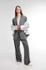 Fashion asian female model in silver down jacket and grey suit.