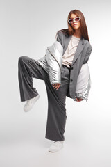 Fashion asian female model in silver down jacket and grey suit.