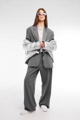 Fashion asian female model in silver down jacket and grey suit. - 651440016