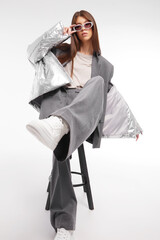 Fashion asian female model in silver down jacket and grey suit. - 651440049