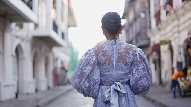 Woman In A Bun Hairstyle Walks At Vigan's Street