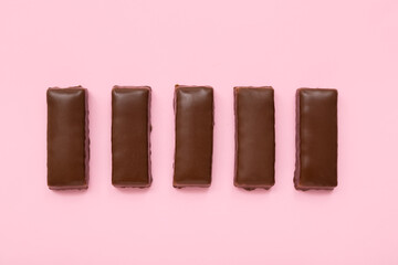 Tasty chocolate covered coconut candies on pink background