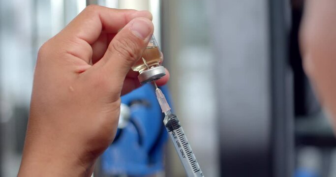 Using syringe suck out of bottle by turning the medicine bottle upside down and slowly pulling the medicine out of the bottle.Syringe with liquid being drawn into syringe.Testosterone.