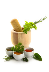 Bowls of spices, herbs and mortar on white background