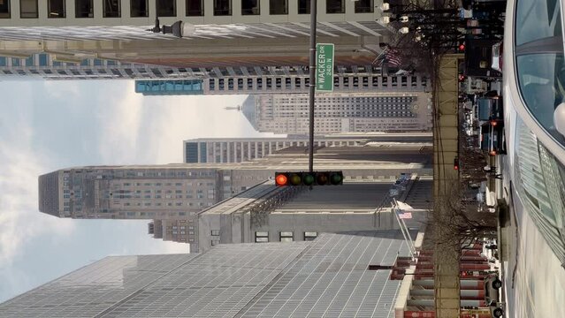 Chicago, Illinois, USA - Mart 21, 2023. vertical shot of People and cars cross the street in downtown . 