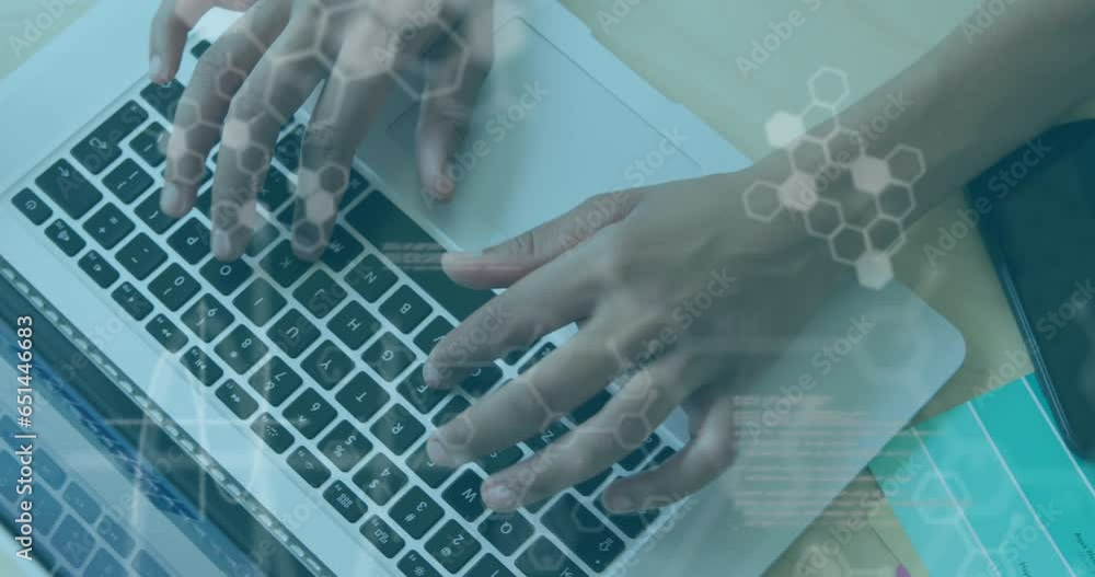 Poster animation of computer language and hexagons, overhead view of cropped hands using laptop