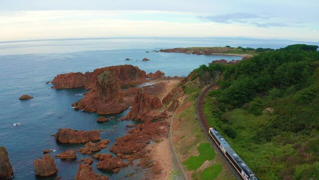 青森県 深浦町にある行合崎付近の奇岩沿いを走行するリゾート列車を俯瞰撮影