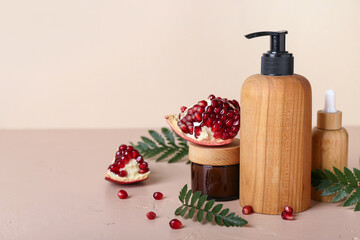 Composition with cosmetic products, pomegranate and fern leaves on color background