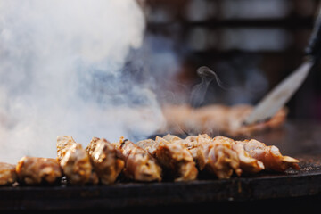 Cook grills chicken kebab steaks open fire. Concept Summer Street food festival