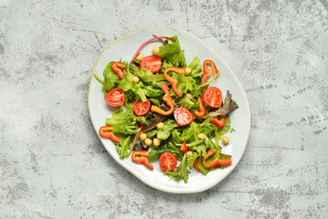 Plate with fresh vegetable salad on grey background