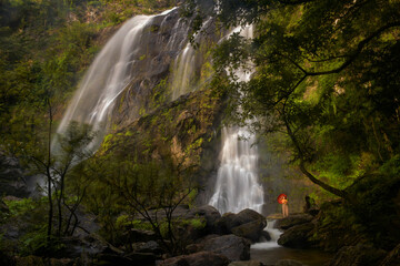 A woman standing at waterfall travel concept
