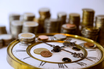stack of coins and old clock