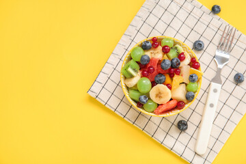 Bowl with fresh fruit salad on yellow background © Pixel-Shot