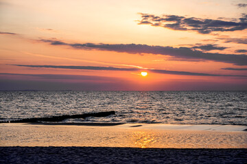Naklejka premium Sunset on the Baltic Sea in Poland. Landscape in the evening with setting sun by the sea.
