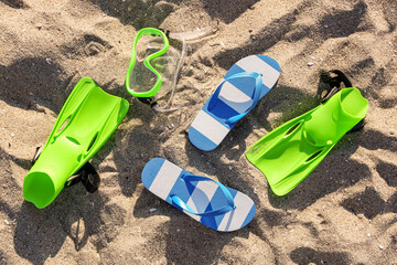 Stylish female blue flip flops, flippers and snorkeling mask on sand © Pixel-Shot