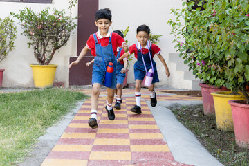 Happy indian school kids running outside the primary school. Education concept.