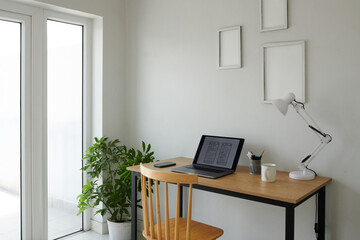 Opened laptop with website wireframe on screen on desk on ui designer