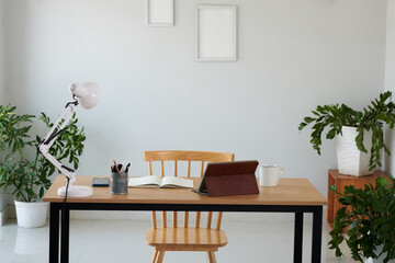 Tablet computer, opened planner and cup of coffee on desk in home office