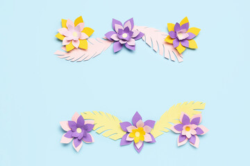 Colorful origami flowers with leaves on blue background