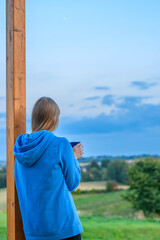 Kobieta pije kawę patrząc na górski pejzaż 