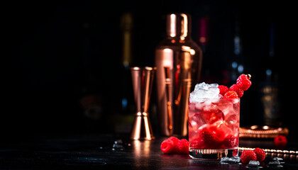 Rosso berry crush red cocktail drink with vermouth, raspberries, currants and ice, dark bar counter...