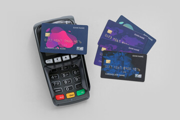 Payment terminal with credit cards on light background