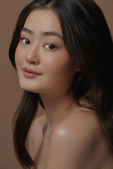 Obraz premium charming asian ethnicity woman with a healthy clean skin over beige isolated. Skin care, cosmetology and plastic surgery concept