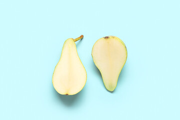 Halves of ripe pear on blue background