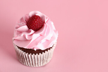 Tasty raspberry cupcake on pink background