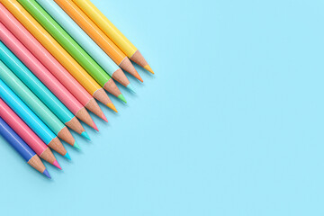 Many colorful pencils on blue background
