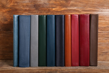 Row of old hardcover books on wooden background, closeup