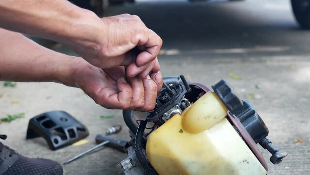 Mechanic is Repairing Gasoline Engine for trimming tree branches.
