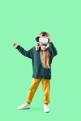 Cute little girl in VR glasses on green background
