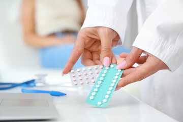 Female gynecologist with contraceptive pills in clinic, closeup