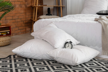 Fototapeta na wymiar Alarm clock on white pillows in bedroom