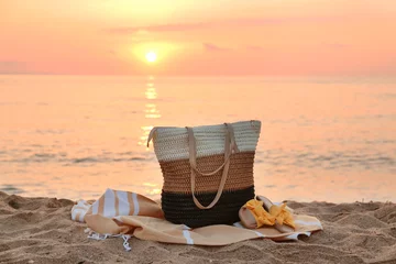  Stylish beach bag, towel and female shoes on sand near sea © Pixel-Shot