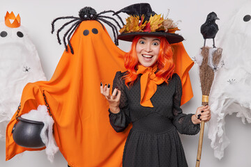 Holiday celebration concept. Indoor photo of young cheerful smiling European woman in costume of...